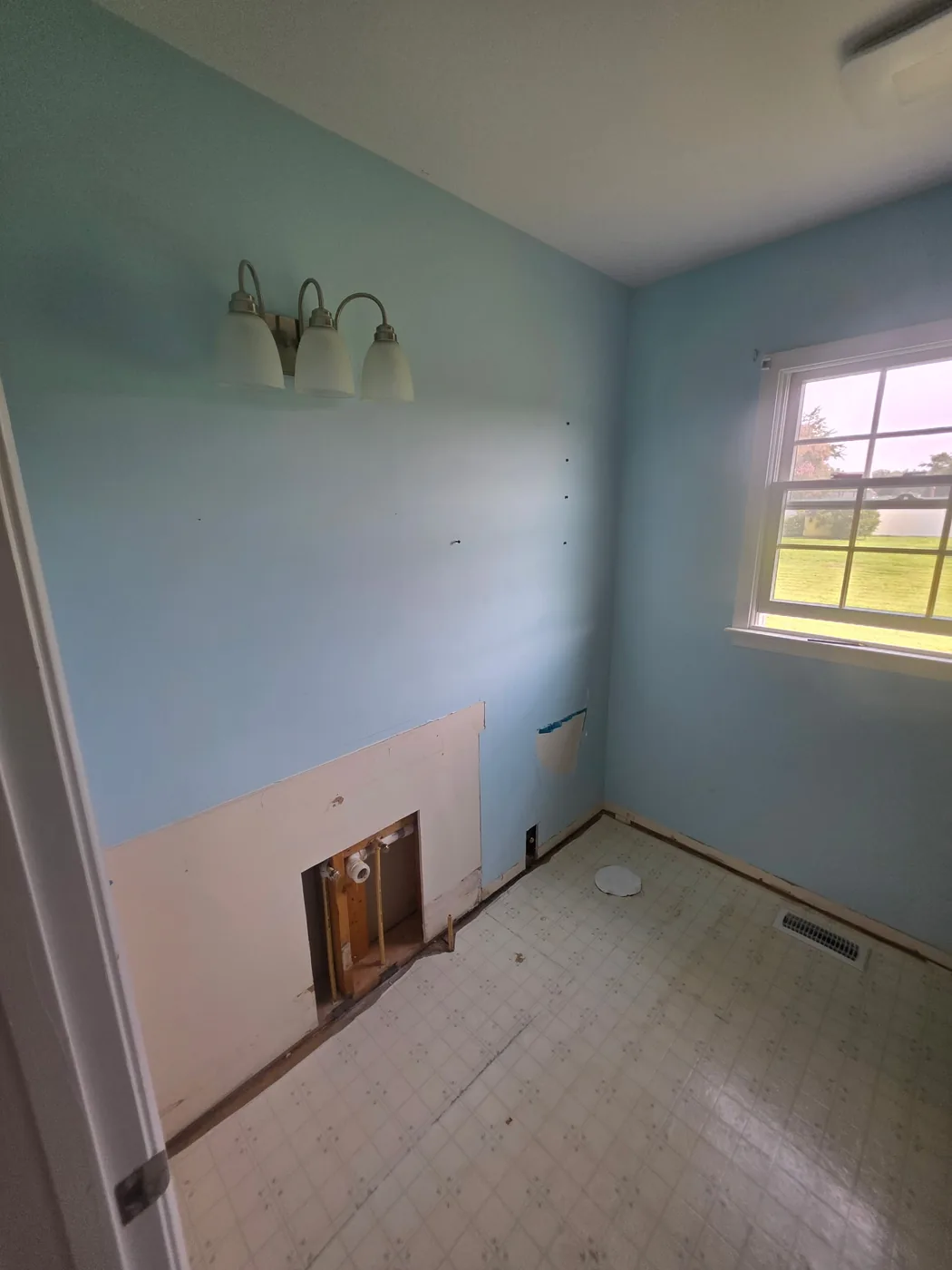 Bathroom demolition in progress in a Dagsboro Delaware home, vanity removed and supply lines exposed