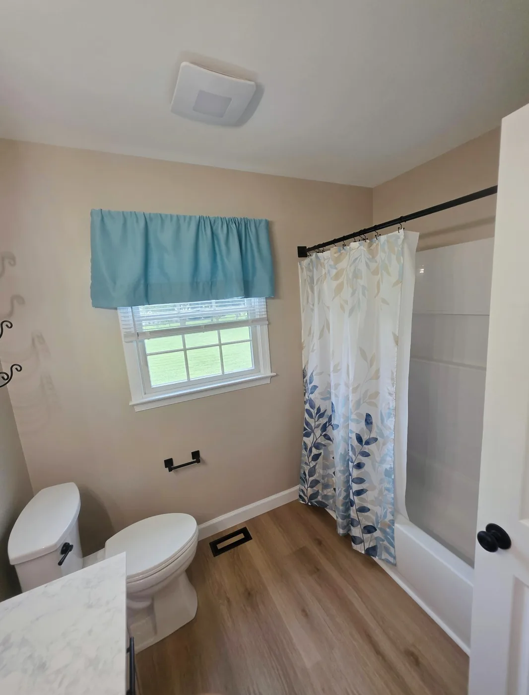 Completed bathroom with new tub surround and luxury vinyl plank flooring in Dagsboro Delaware