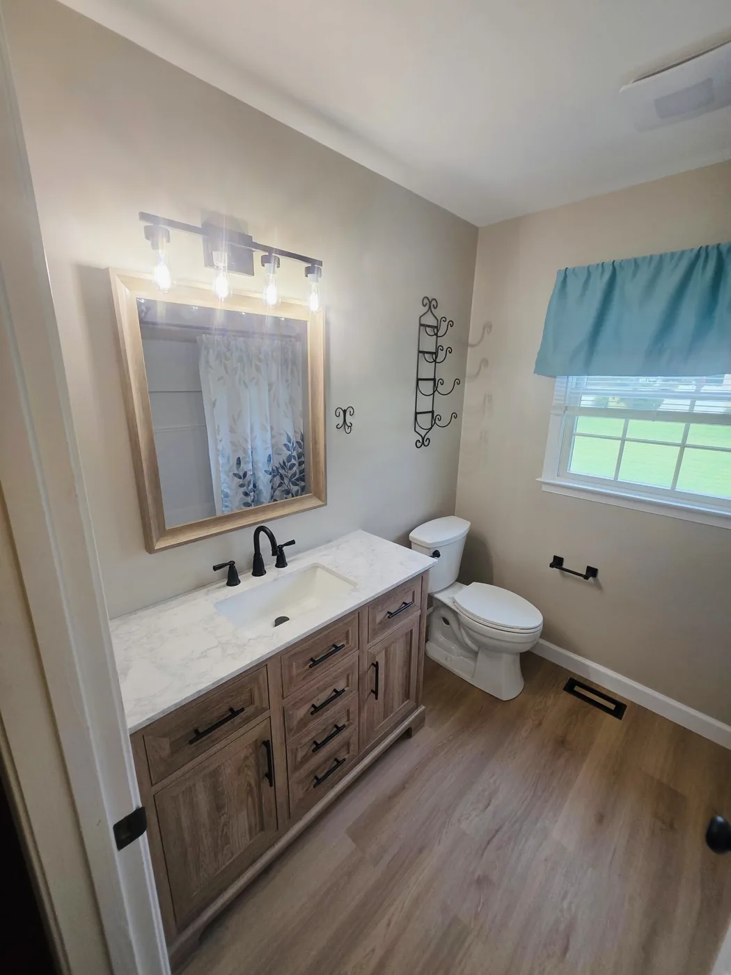 Finished vanity, framed mirror and light fixture in a completed Dagsboro Delaware bathroom