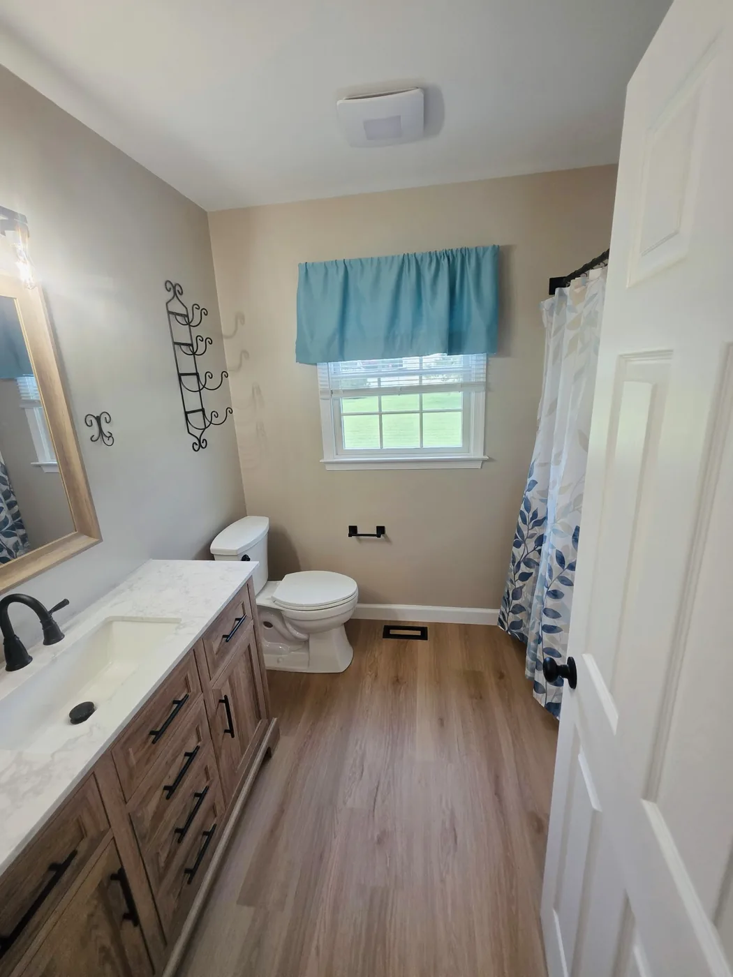 Completed Dagsboro DE bathroom with quartz top vanity, new toilet and vinyl plank floor
